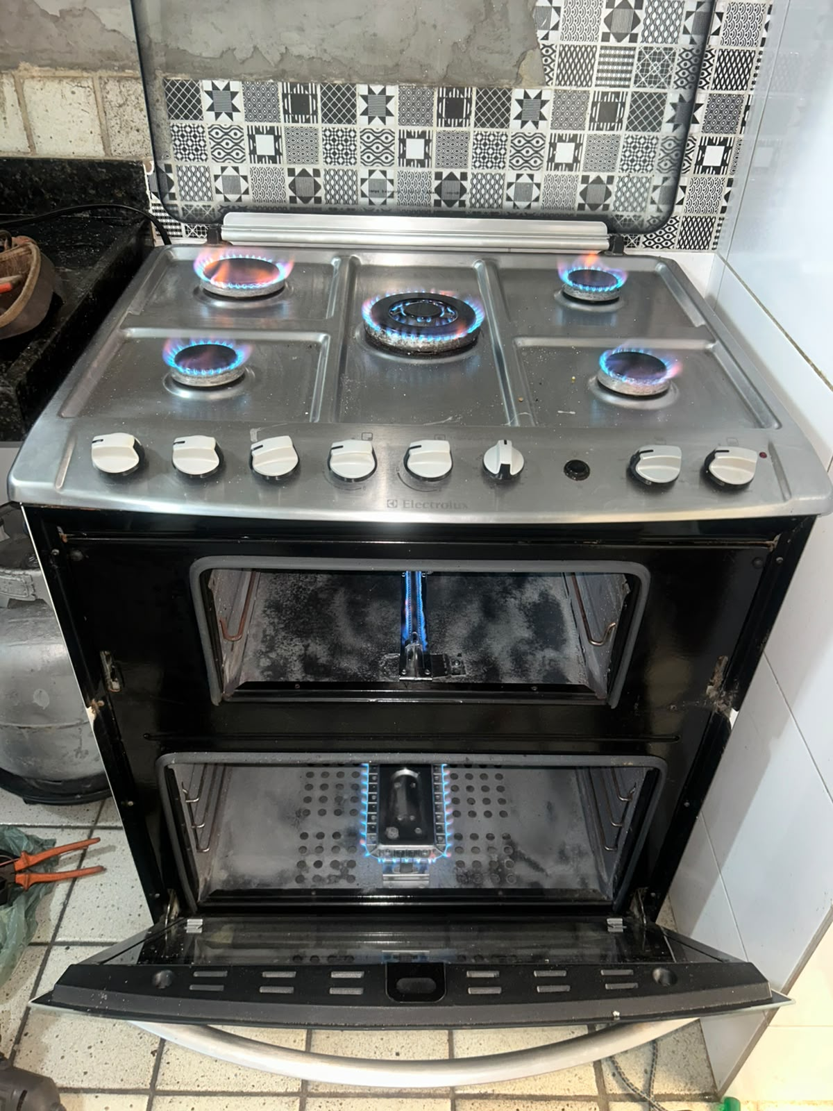 Fogão Electrolux após o serviço: queimadores e forno limpos, com chama azul acesa